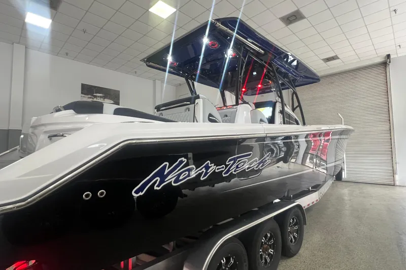Slide: The Image of 2026 Nor-Tech 390 Sport Center Console boat in showroom, featuring sleek design and modern features. - 11