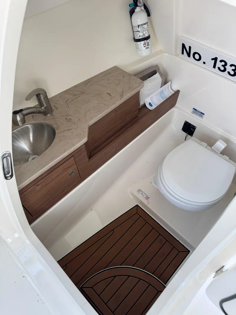 Slide: The Image of 2022 Boston Whaler 280 Vantage boat bathroom with sink, toilet, and wooden flooring. - 13