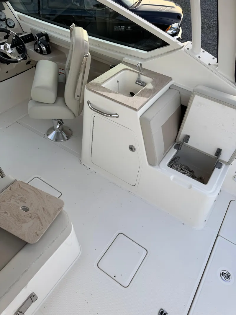 Slide: The Image of Interior of 2022 Boston Whaler 280 Vantage boat with seating, sink, and storage. - 16
