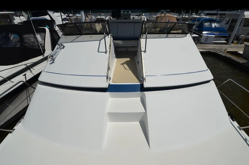 Slide: The Image of 1989 Carver Santego 3867 yacht docked at marina, showcasing spacious deck and sleek design. - 11