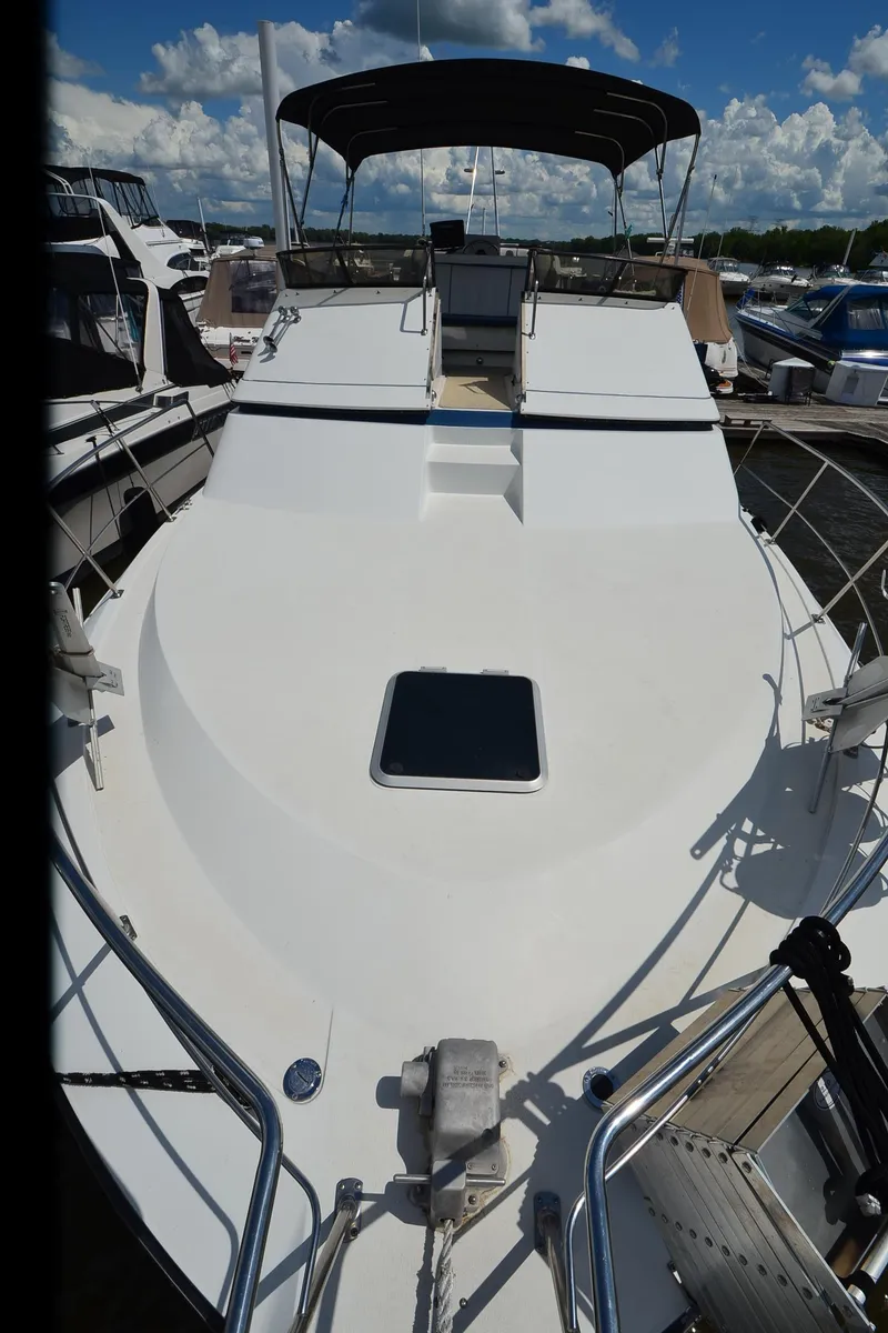 Slide: The Image of 1989 Carver Santego 3867 yacht docked, featuring spacious deck and sleek design under blue sky. - 12