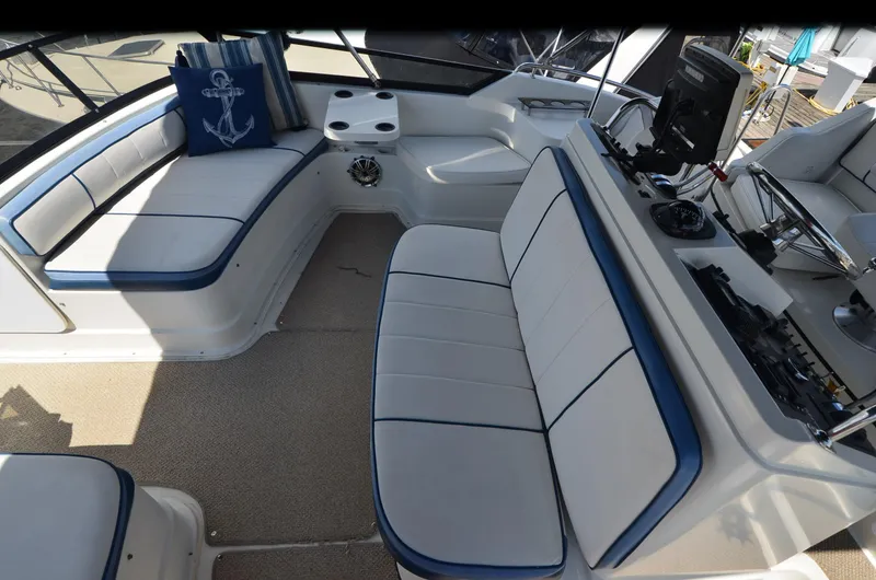 Slide: The Image of 1989 Carver Santego 3867 boat interior with white seating, blue accents, and nautical decor. - 13