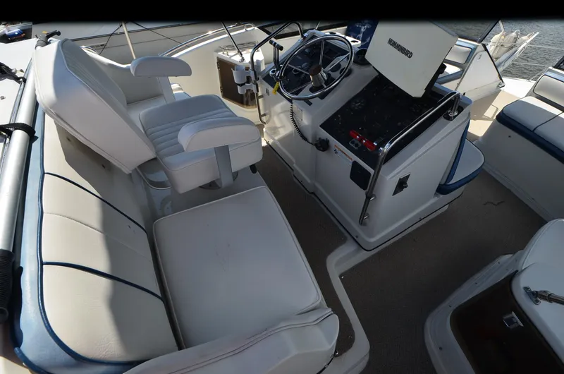 Slide: The Image of 1989 Carver Santego 3867 boat helm with white seating and steering console. - 15