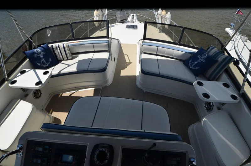 Slide: The Image of 1989 Carver Santego 3867 boat interior with cushioned seating and nautical-themed pillows. - 16