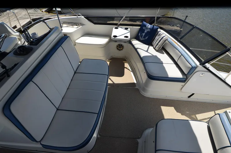 Slide: The Image of 1989 Carver Santego 3867 boat interior with cushioned seating and nautical-themed decor. - 21