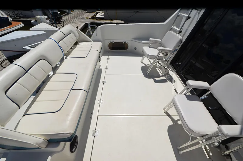 Slide: The Image of 1989 Carver Santego 3867 yacht deck with white seating and chairs. - 4