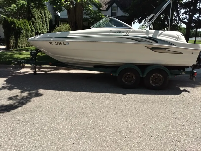 Slide: The Image of 2001 Sea Ray 190 Bow Rider boat on trailer, parked on a residential street. - 3