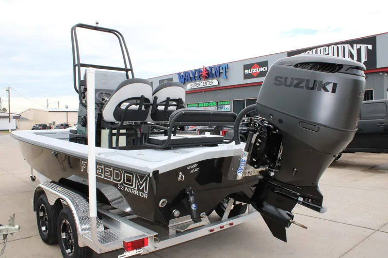 Slide: The Image of 2025 Freedom Boats 23' Warrior with Suzuki engine on trailer at dealership. - 2