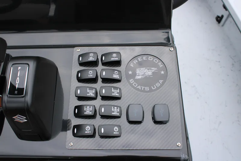 Slide: The Image of Control panel of 2025 Freedom Boats 23' Warrior with various switches and logo. - 17