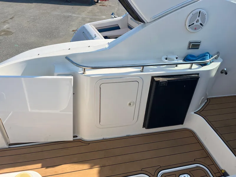Slide: The Image of 2004 Cruisers Yachts 320 Express deck with fridge and storage compartments. - 11