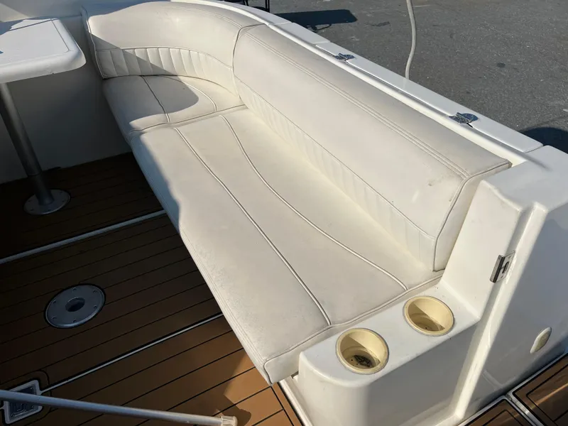 Slide: The Image of 2004 Cruisers Yachts 320 Express interior with white seating and wooden flooring. - 12