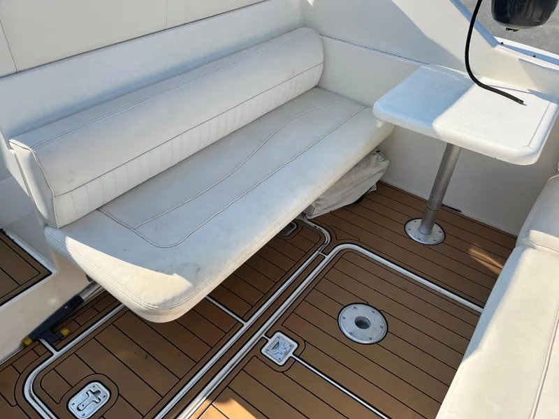Slide: The Image of 2004 Cruisers Yachts 320 Express interior with white seating and wooden flooring. - 13