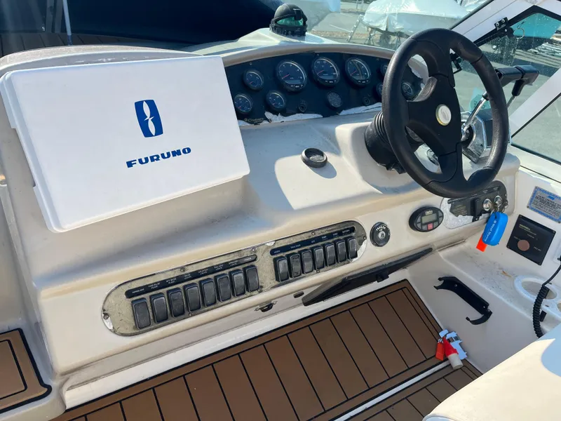 Slide: The Image of 2004 Cruisers Yachts 320 Express helm with Furuno navigation system and steering wheel. - 14