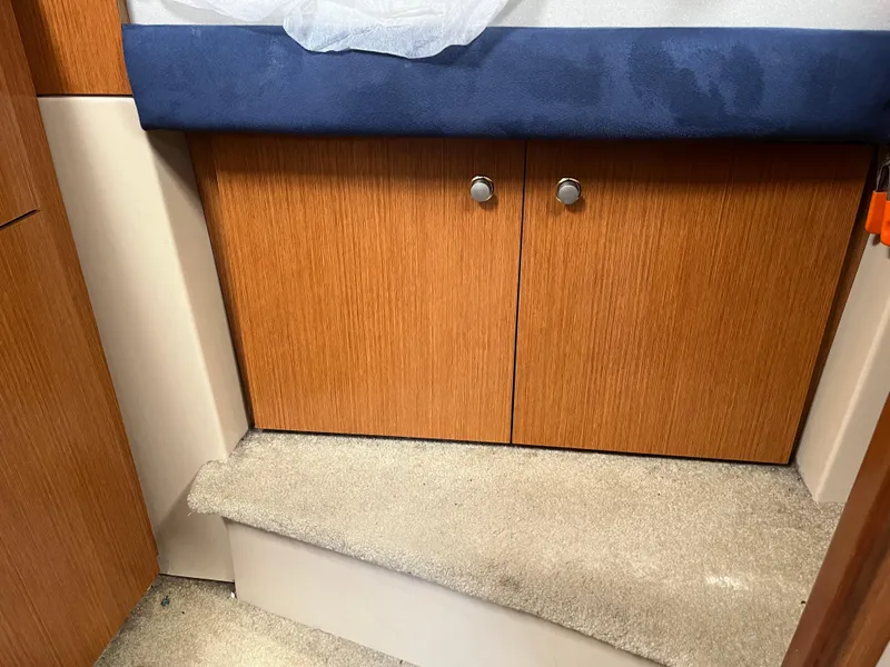 Slide: The Image of 2004 Cruisers Yachts 320 Express interior with wooden cabinets and carpeted step. - 20