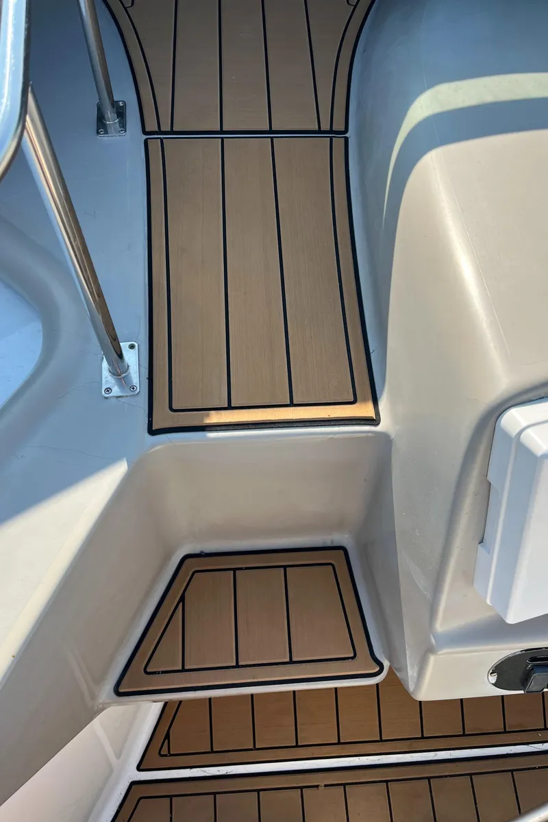 Slide: The Image of 2004 Cruisers Yachts 320 Express boat deck with teak-style flooring and stainless steel railing. - 22