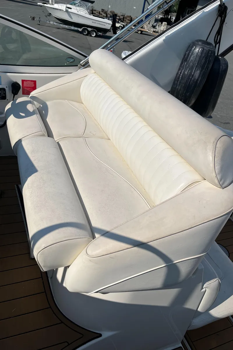 Slide: The Image of 2004 Cruisers Yachts 320 Express boat with white leather seating on deck. - 23