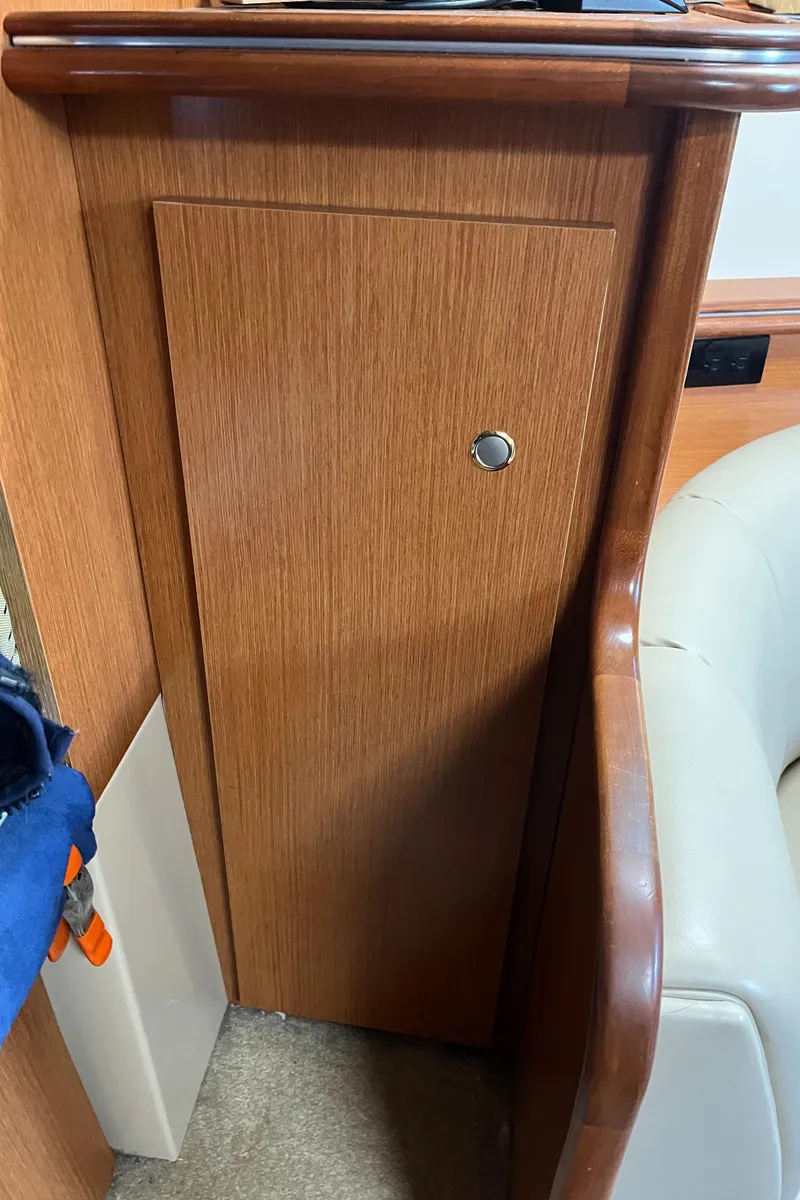 Slide: The Image of 2004 Cruisers Yachts 320 Express interior with wooden cabinet and beige seating. - 25