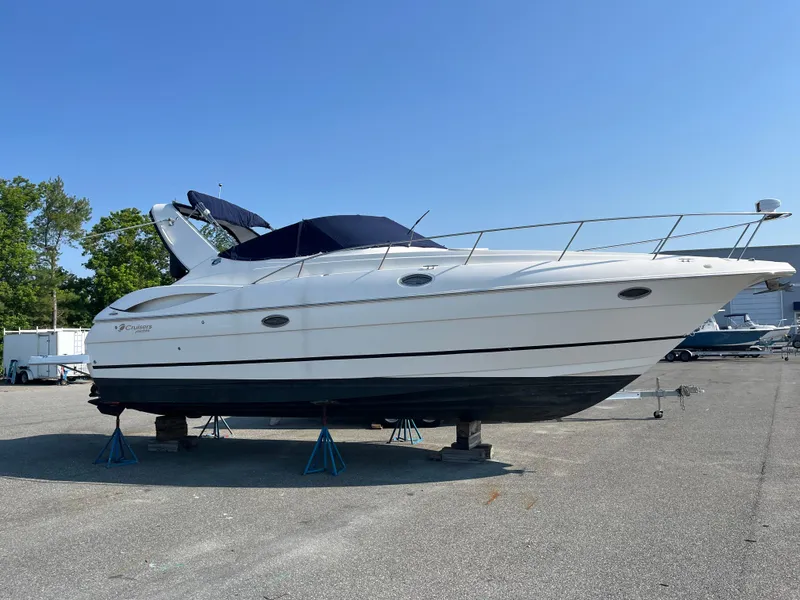 Slide: The Image of 2004 Cruisers Yachts 320 Express on stands, outdoor display, clear sky background. - 4