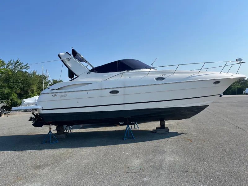 Slide: The Image of 2004 Cruisers Yachts 320 Express on stands in a parking lot, side view. - 5