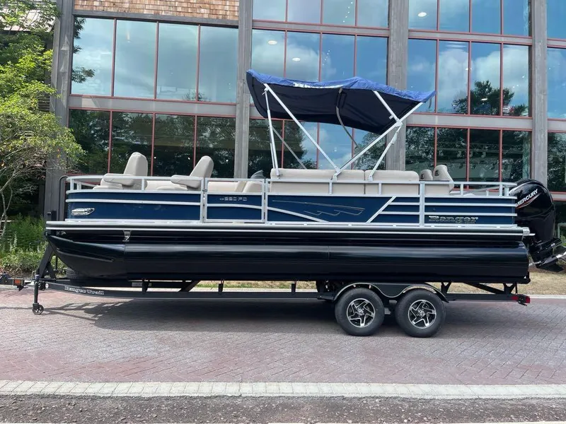 The Image of 2025 Ranger Reata 220FC pontoon boat with canopy, parked on a trailer. - 0