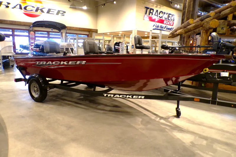 The Image of 2025 Tracker Super Guide V-16 T boat displayed in showroom, red exterior, on trailer. - 0