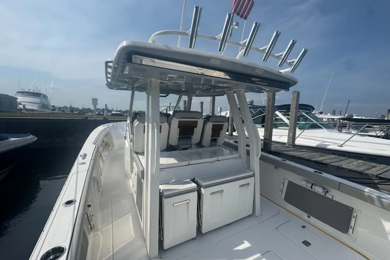 Slide: The Image of 2024 Pursuit S 358 Sport boat docked, showcasing sleek design and spacious deck. - 11