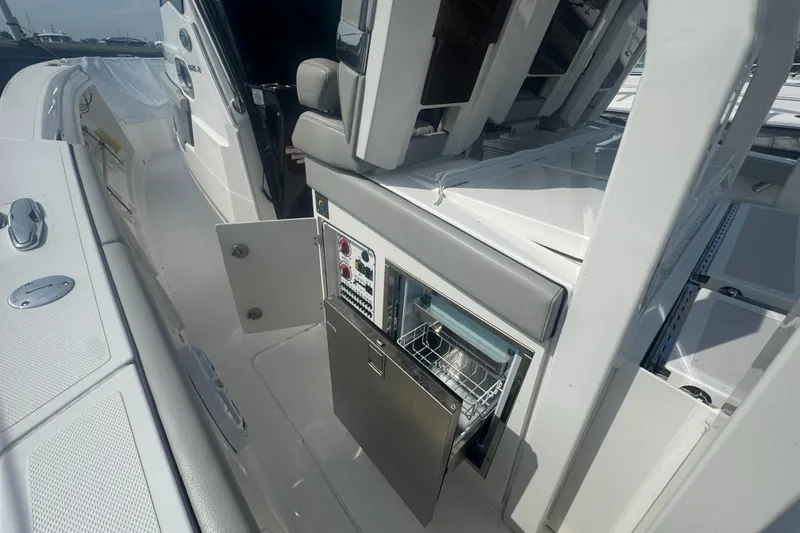 Slide: The Image of 2024 Pursuit S 358 Sport boat interior with open storage and control panel. - 12