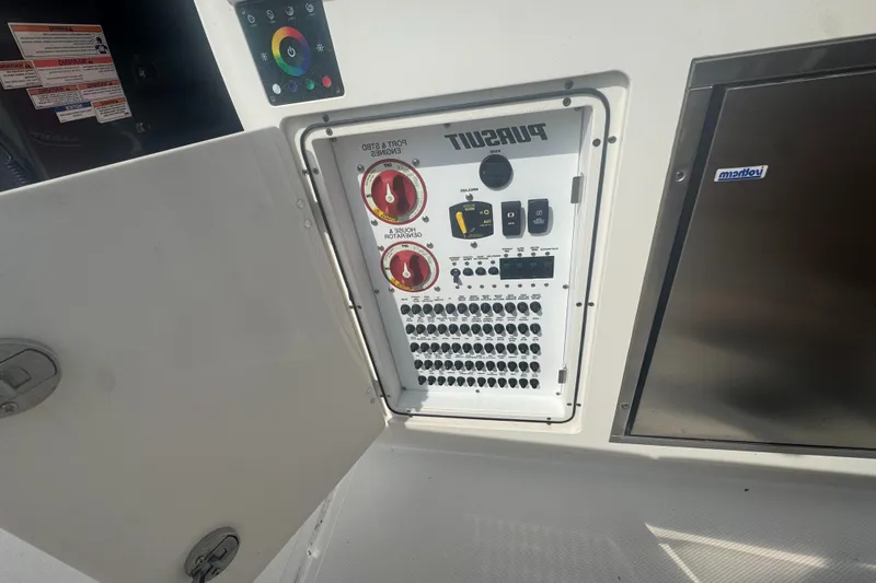 Slide: The Image of 2024 Pursuit S 358 Sport control panel with switches and dials, open compartment. - 13