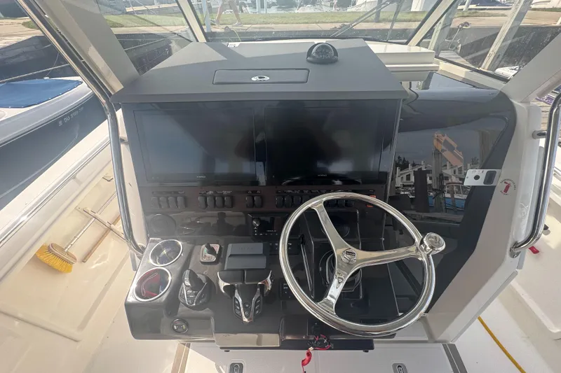 Slide: The Image of 2024 Pursuit S 358 Sport boat helm with steering wheel and control panel. - 18