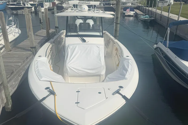 Slide: The Image of 2024 Pursuit S 358 Sport boat docked in marina, front view. - 2