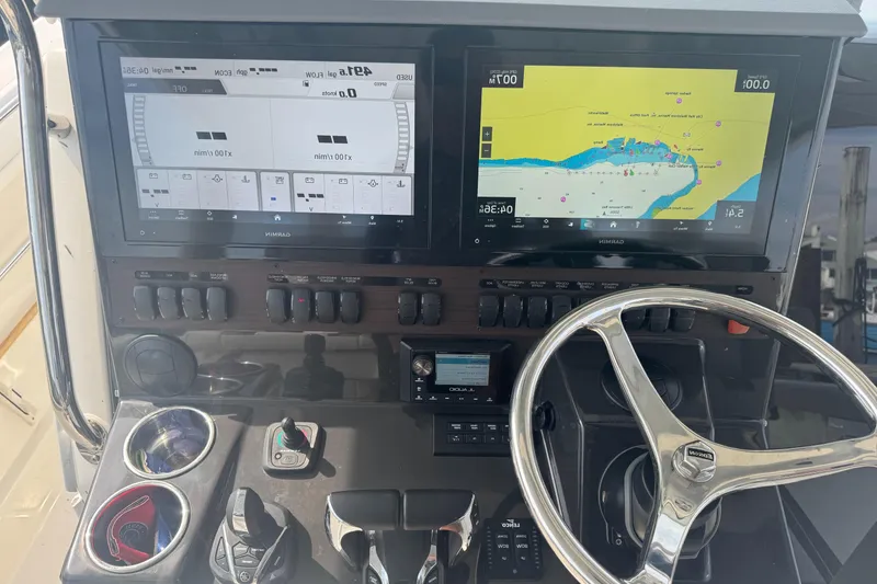 Slide: The Image of 2024 Pursuit S 358 Sport boat dashboard with navigation screens and steering wheel. - 21