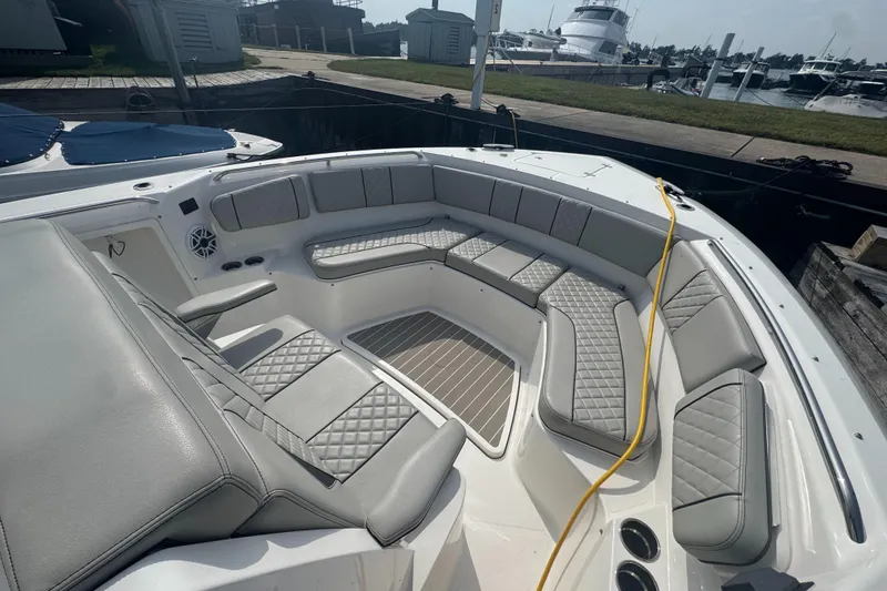Slide: The Image of 2024 Pursuit S 358 Sport boat with luxurious seating at a marina. - 23