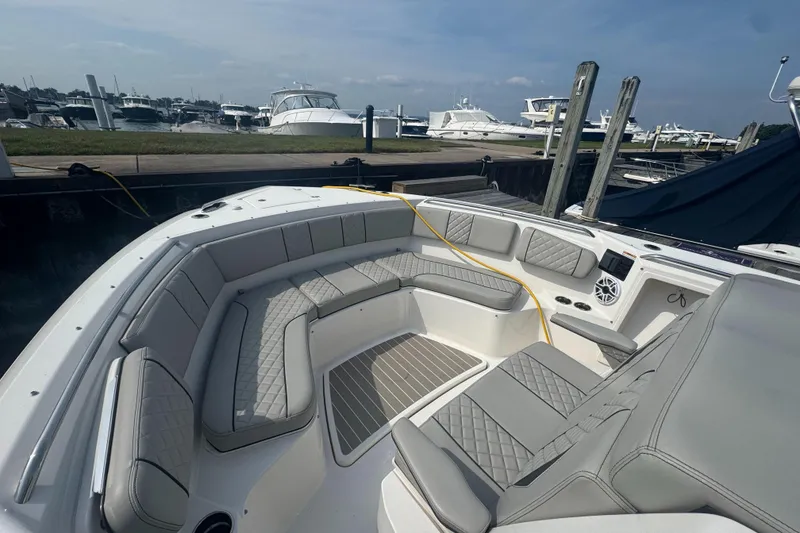Slide: The Image of 2024 Pursuit S 358 Sport boat with spacious seating at a marina. - 24