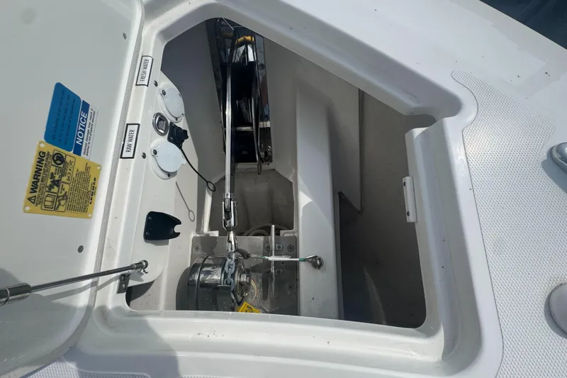 Slide: The Image of 2024 Pursuit S 358 Sport boat anchor compartment with winch and safety labels. - 26
