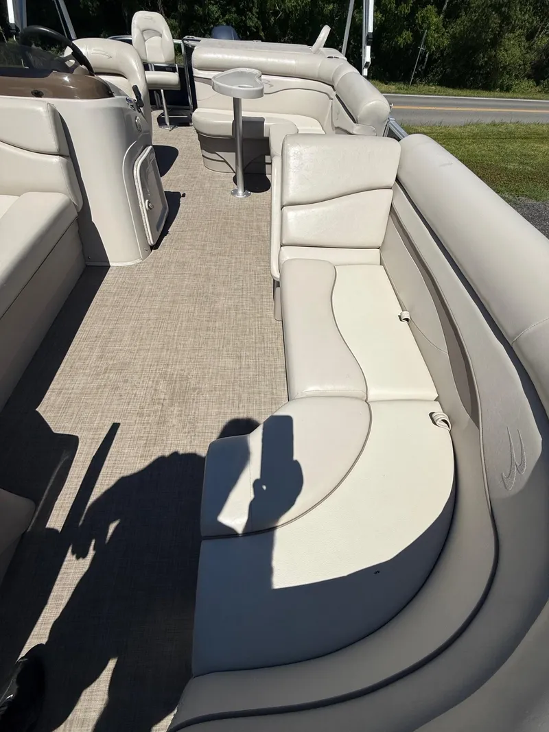 Slide: The Image of 2016 Bennington 22 SX pontoon boat interior with beige seating and carpet. - 12