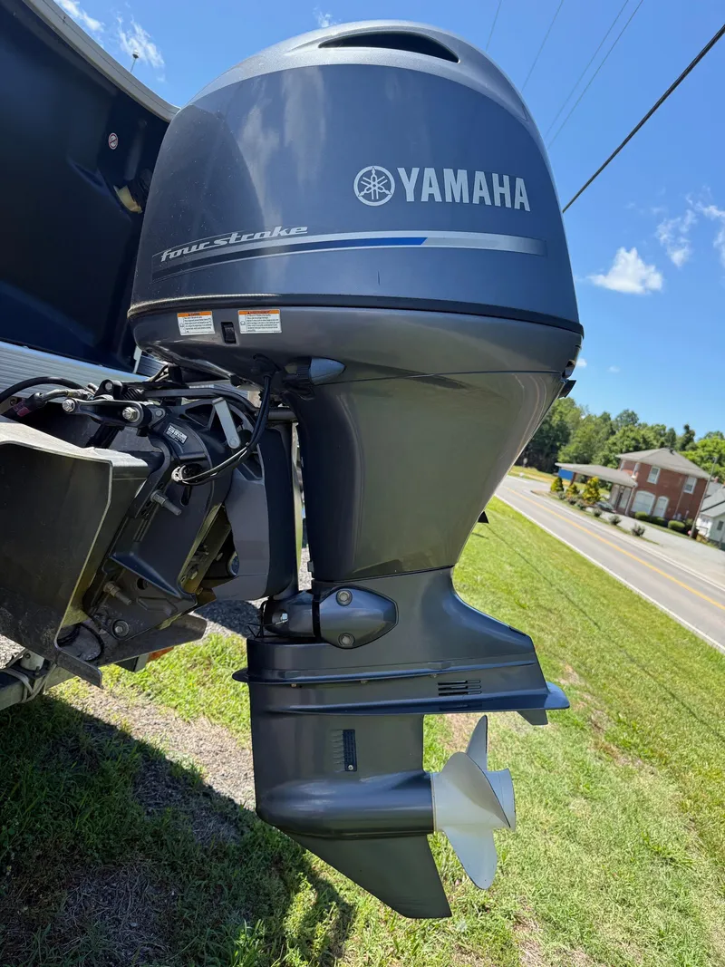 Slide: The Image of Yamaha four-stroke outboard motor on a 2016 Bennington 22 SX boat, parked on grass. - 14