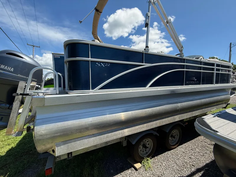 Slide: The Image of 2016 Bennington 22 SX pontoon boat on trailer under clear blue sky. - 2