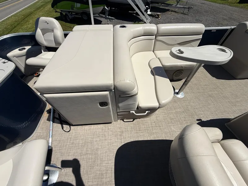 Slide: The Image of 2016 Bennington 22 SX pontoon boat interior with beige seating and table. - 7