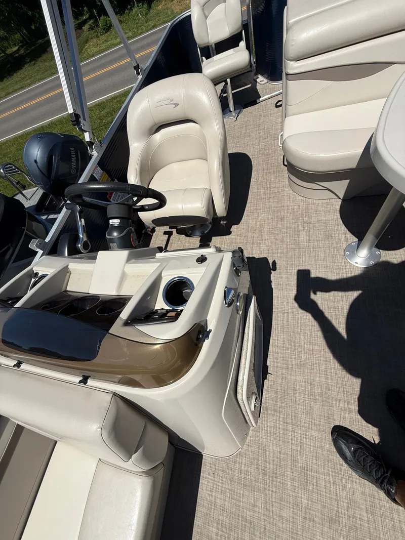 Slide: The Image of 2016 Bennington 22 SX boat interior with beige seating and steering console. - 9