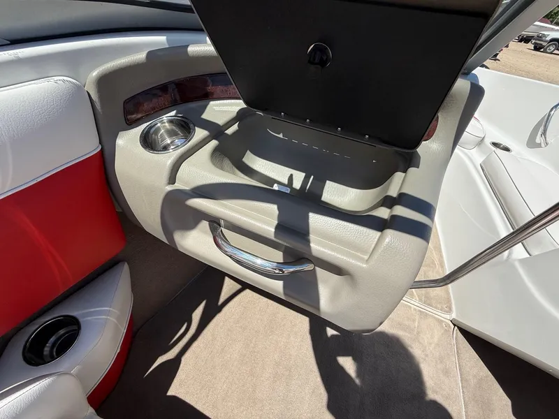Slide: The Image of 2012 Crownline 18 SS boat interior with open glove compartment and cup holder. - 17