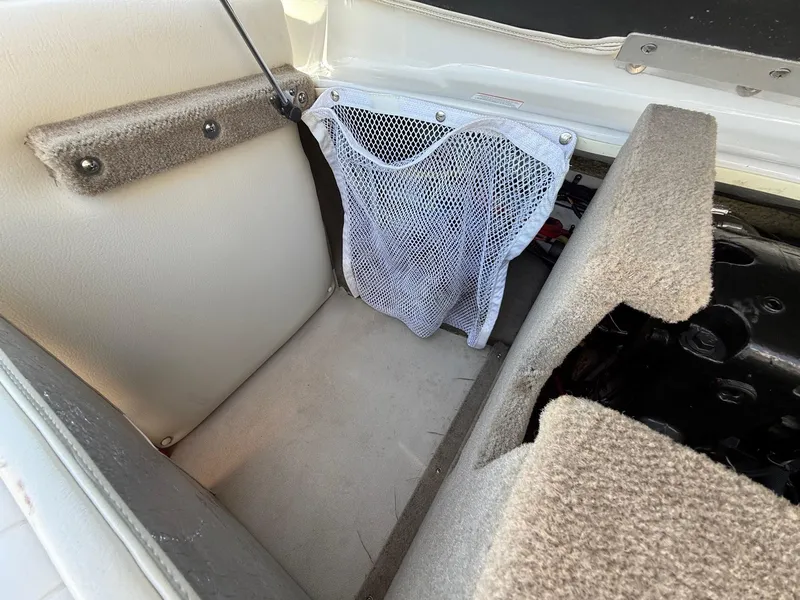 Slide: The Image of Interior storage compartment of a 2012 Crownline 18 SS boat with netting and carpeted surfaces. - 23