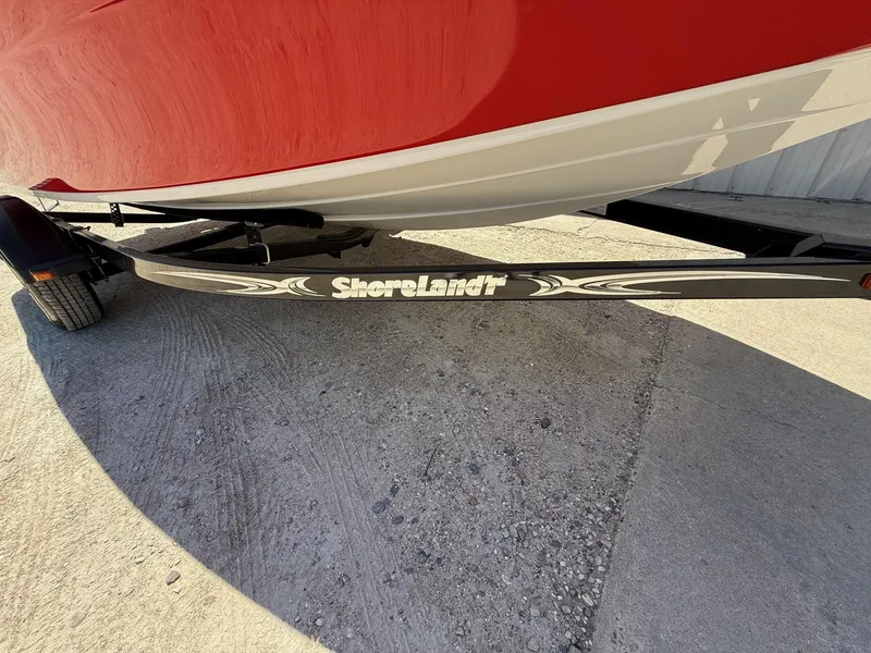 Slide: The Image of Red 2012 Crownline 18 SS boat on ShoreLand'r trailer, parked on concrete surface. - 26