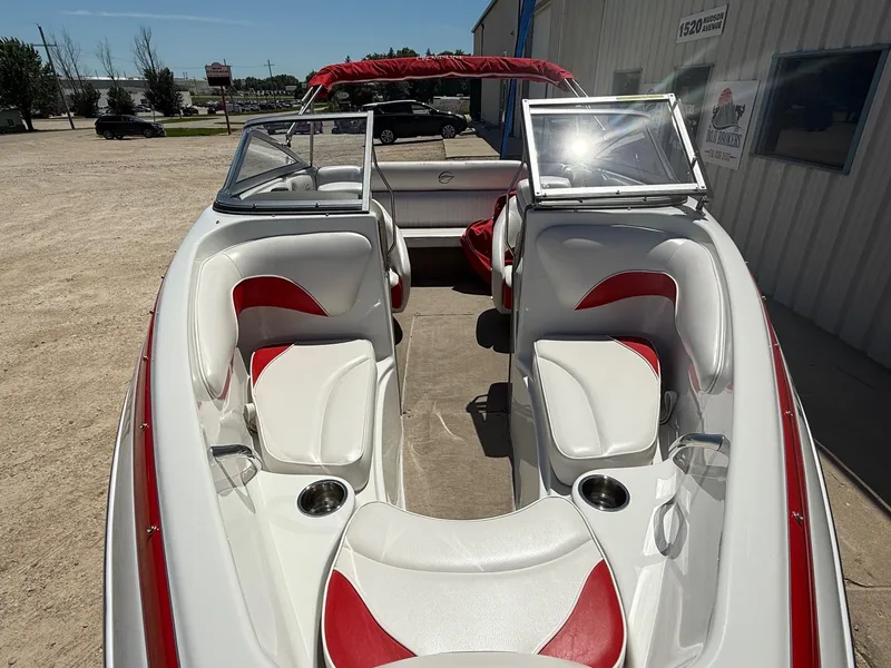 Slide: The Image of 2012 Crownline 18 SS boat interior with red and white seating, cup holders, and open windshield. - 3