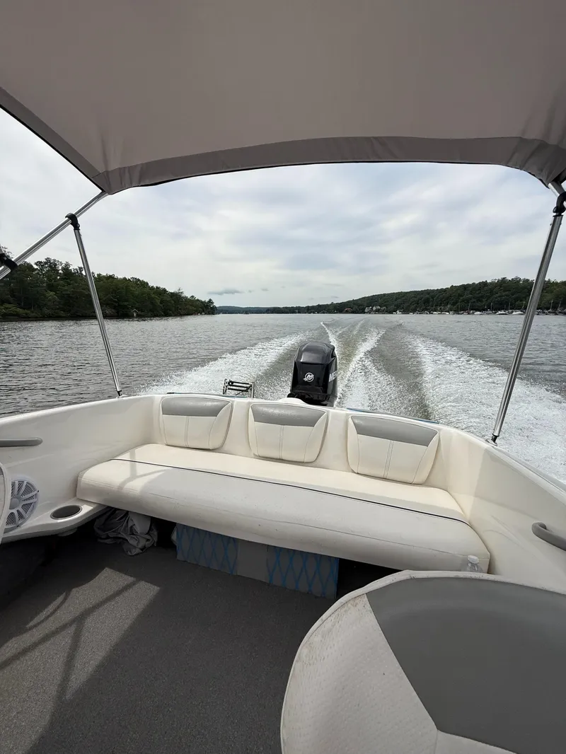 Slide: The Image of 2013 Bayliner 160 Bowrider cruising on a lake, view from under the canopy. - 4