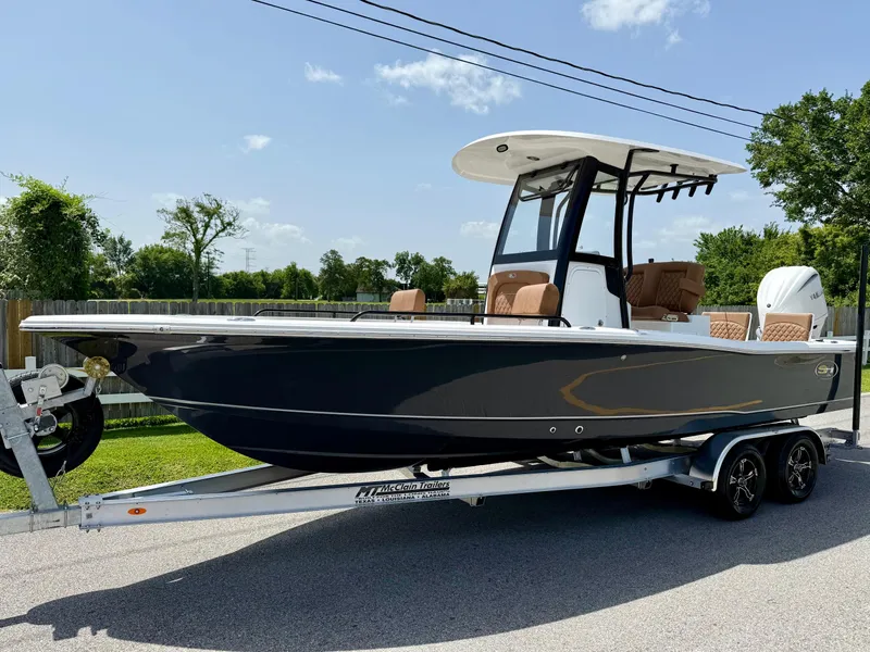 Slide: The Image of 2026 Sea Hunt BX 25 FS boat on trailer, parked outdoors under clear sky. - 1