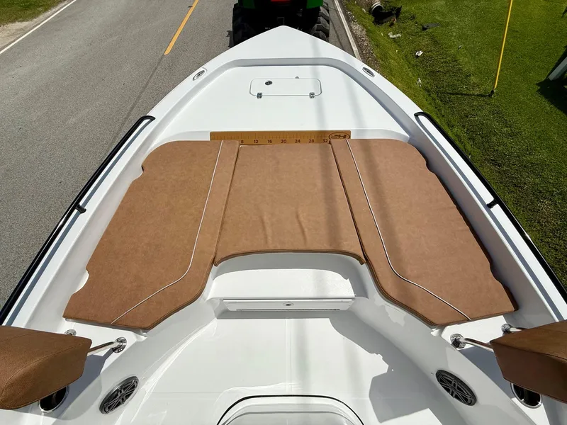Slide: The Image of 2026 Sea Hunt BX 25 FS boat deck with brown cushioned seating and measuring ruler. - 15