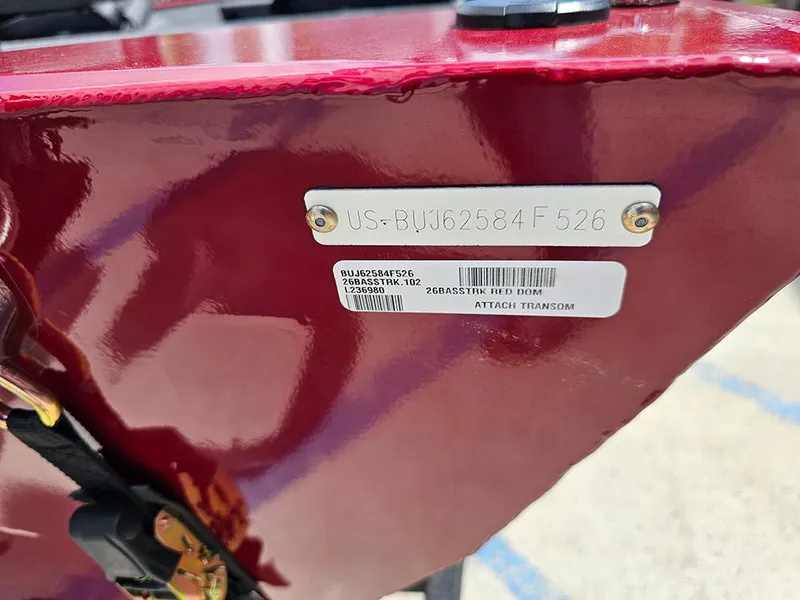 Slide: The Image of 2026 Tracker Bass Tracker Classic XL boat identification plate on red hull. - 21