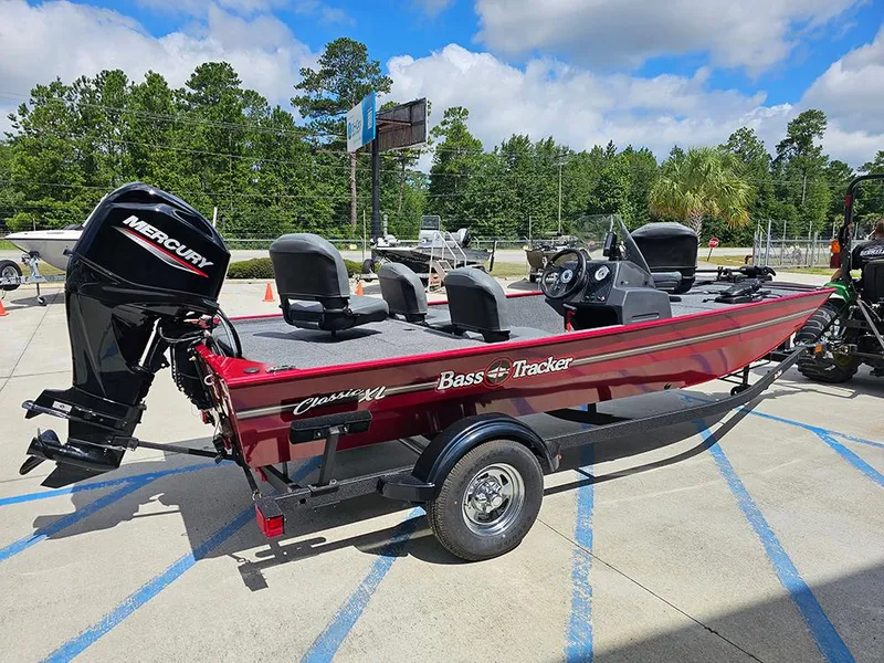 Slide: The Image of 2026 Tracker Bass Tracker Classic XL boat with Mercury engine, parked outdoors. - 7