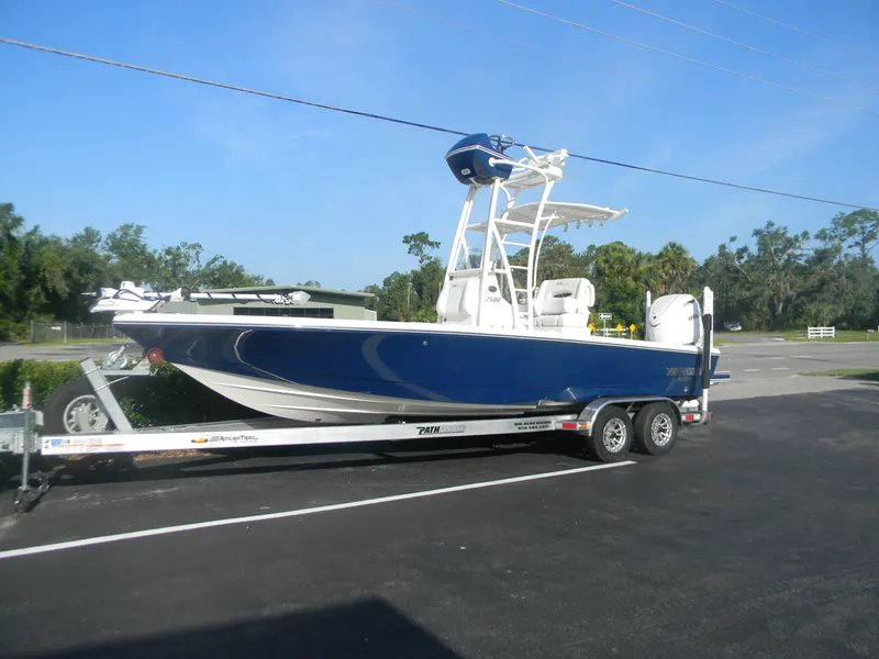 Slide: The Image of 2026 Pathfinder 2500 Hybrid boat on trailer, parked outdoors under clear sky. - 8