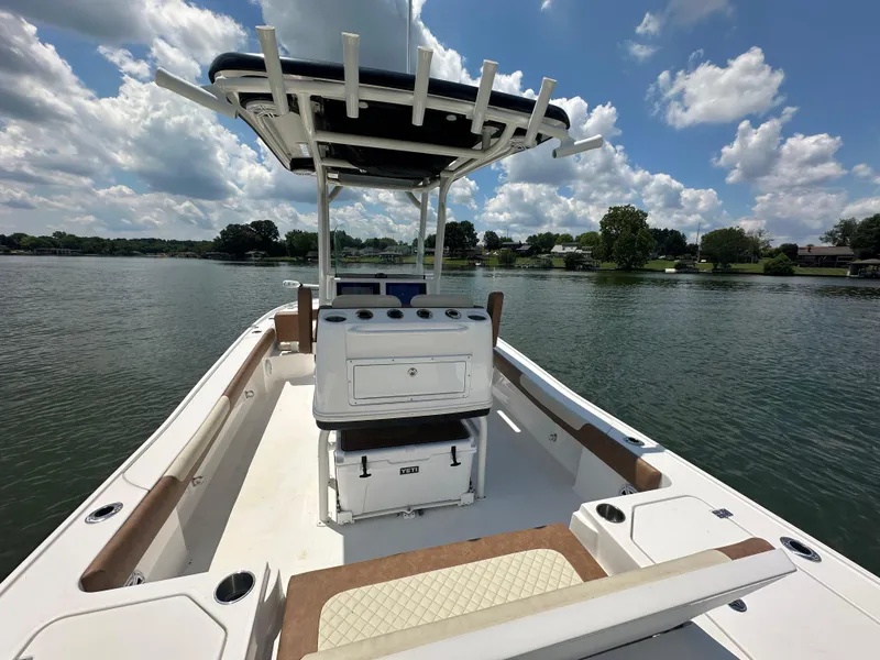 Slide: The Image of 2023 Caymas 26 HB boat on a serene lake under a partly cloudy sky. - 19